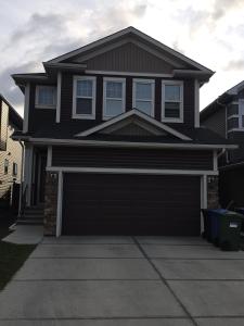 a house with a garage door in a driveway at Cozy New 2BR Suite Retreat in Calgary