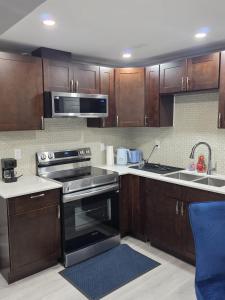 a kitchen with wooden cabinets and a stove top oven at Cozy New 2BR Suite Retreat in Calgary