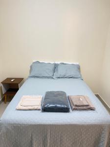 a bed with blue pillows and towels on it at Casa 20 in Araguaína