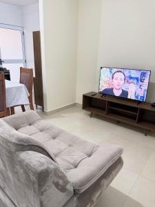 a living room with a couch and a flat screen tv at Casa 20 in Araguaína