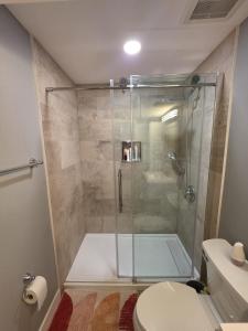 a bathroom with a shower and a toilet at Cozy New 2BR Suite Retreat in Calgary +8 photos