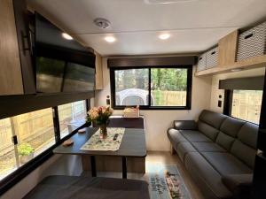 a living room with a couch and a table at Rest Up Retreat-New Lux RV-Private-6Flags-Fire Pit-Hammock-Atlanta in Atlanta