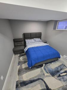 a bedroom with a blue bed and a rug at Cozy New 2BR Suite Retreat in Calgary