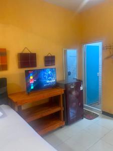 a living room with a tv on a wooden table at Harry & Mimin Homestay in Gorontalo