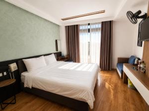 a hotel room with a bed and a window at Ngan Hoa - Mille Fleurs 02 in Da Lat