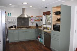 a kitchen with white cabinets and a sink and a refrigerator at The Audobon Escape in Aiken