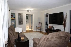 a living room with two couches and a flat screen tv at The Audobon Escape in Aiken
