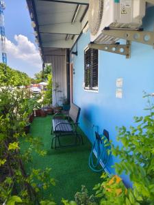 a patio with a chair and green grass at บ้านสุขสันต์ พฤกษา45 บางใหญ่ in Ban Nong Kradi