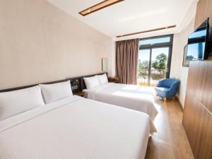 a hotel room with two beds and a tv at Ngan Hoa - Mille Fleurs 02 in Da Lat +31 photos