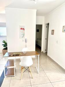 a desk with a white chair in a room at Lumar Apart Boituva Diária 24H in Boituva