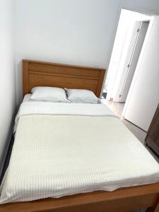 a bedroom with a large bed with white sheets at Lumar Apart Boituva Diária 24H in Boituva +3 photos