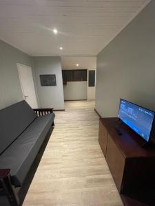 a living room with a couch and a flat screen tv at Casa Calma in Eldorado