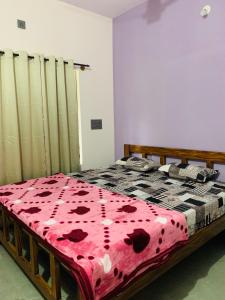 a bedroom with a bed with a red blanket on it at Naisarga hill view homestay in Somvārpet