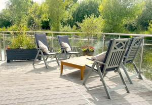 three chairs and a table on a deck at The Floating Home at Upton in Upton upon Severn
