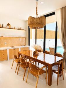 a kitchen and dining room with a wooden table and chairs at Tim Kanya Pranburi in Pran Buri