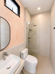 a bathroom with a toilet and a sink and a shower at Tim Kanya Pranburi in Pran Buri +5 photos