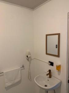 a white bathroom with a sink and a mirror at Zenora Suites in San José