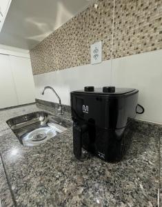a kitchen counter with a sink and a mixer at Studio Blanc - Espaço e conforto com uma vista incrivel in Barbacena +13 photos