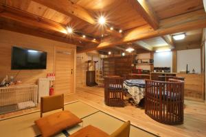 a living room with wooden walls and a tv and a crib at 千年乃宿 in Kubo