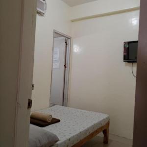 a small room with a bed and a mirror at Walk Inn Dipolog City by RedDoorz in Dipolog