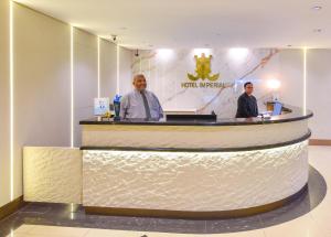 two men standing at the counter of a hotel lobby at Hotel Imperial in Kuala Lumpur