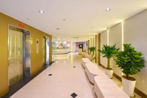 a hallway with benches and potted plants in a building at Hotel Imperial in Kuala Lumpur