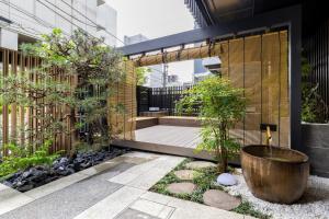 a garden with a courtyard with trees and a building at Morikoya Hotel in Tokyo