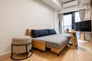 a bedroom with a bed and a chair and a tv at Morikoya Hotel in Tokyo