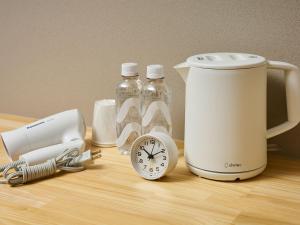 a counter with a blender and bottles and a clock at SMART PLACE iNN Hakata-Gion in Fukuoka