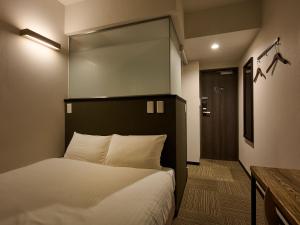 a bedroom with a bed with a mirror above it at SMART PLACE iNN Hakata-Gion in Fukuoka
