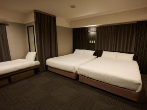 a hotel room with two beds and curtains at SMART PLACE iNN Hakata-Gion in Fukuoka