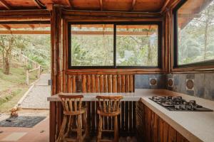 a kitchen with a stove and two stools at Mantoverde in Dosquebradas