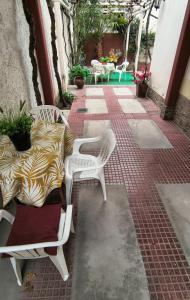 a patio with white chairs and tables with plants at Complejo turistico ALOJARTUR in San Rafael