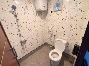 a bathroom with a toilet and a shower with confetti at Contana Paris in Girijati