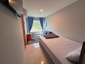a small bedroom with a bed and a window at Contana Paris in Girijati