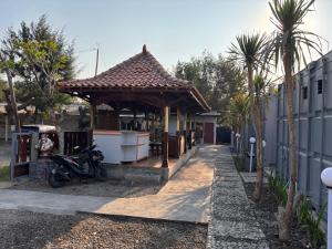 a motorcycle parked next to a building with a gazebo at Contana Paris in Girijati