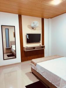 a bedroom with a flat screen tv and a mirror at Hotel del Parque Arauca in Arauca