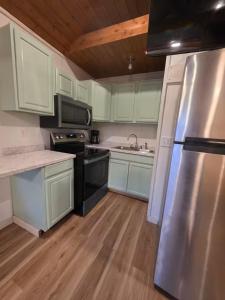 a kitchen with white cabinets and a stainless steel refrigerator at River Run Maggie's house in Kerrville
