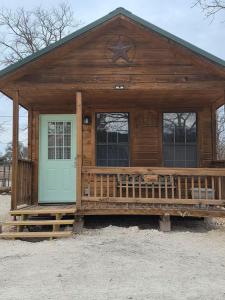 a large wooden cabin with a porch and a door at River Run Maggie's house in Kerrville