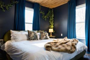 a bedroom with a large bed with blue walls at 5BR Hocking Hills Cabin, Arcade, Forest Views in South Bloomingville