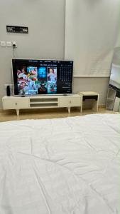 a bedroom with a large flat screen tv on a table at بيّت الضيافة in Al Baha