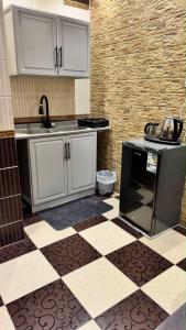 a kitchen with white cabinets and a black stove at بيّت الضيافة in Al Baha