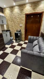 a living room with a couch and a checkered floor at بيّت الضيافة in Al Baha