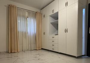 a room with white cabinets and a window at Mountain Escape with Rooftop in Jūrat Arşūn +3 photos
