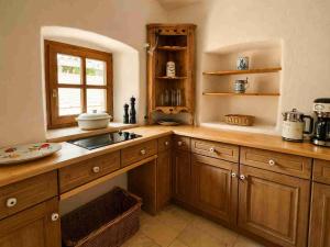 a kitchen with wooden cabinets and a sink and a window at Torwärterhaus Kipfenberg-Arnsberg in Arnsberg +25 photos