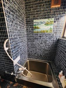 a bathroom with a sink and blue tiled walls at TOTONOU Place in Asahikawa
