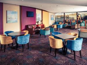 a hotel lobby with tables and chairs and a couch at Mercure Manchester Piccadilly Hotel in Manchester