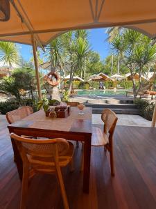 a wooden table and chairs on a patio at Gili Tenda in Gili Trawangan