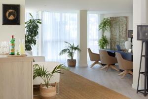 a living room with a dining room table and plants at Meliá Cala Galdana in Cala Galdana