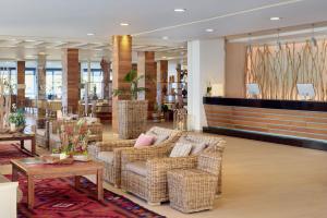 a lobby with wicker chairs and tables in a store at Meliá Cala Galdana in Cala Galdana